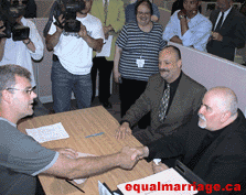 A city employee congratulates the happy couple as they receive their marriage licence (Photo by equalmarriage.ca, 2003)